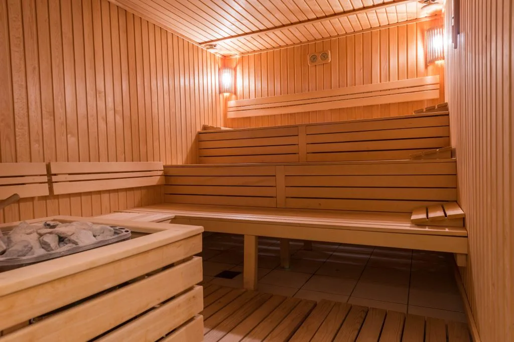 Wooden benches and walls create a warm, inviting sauna atmosphere with soft lighting