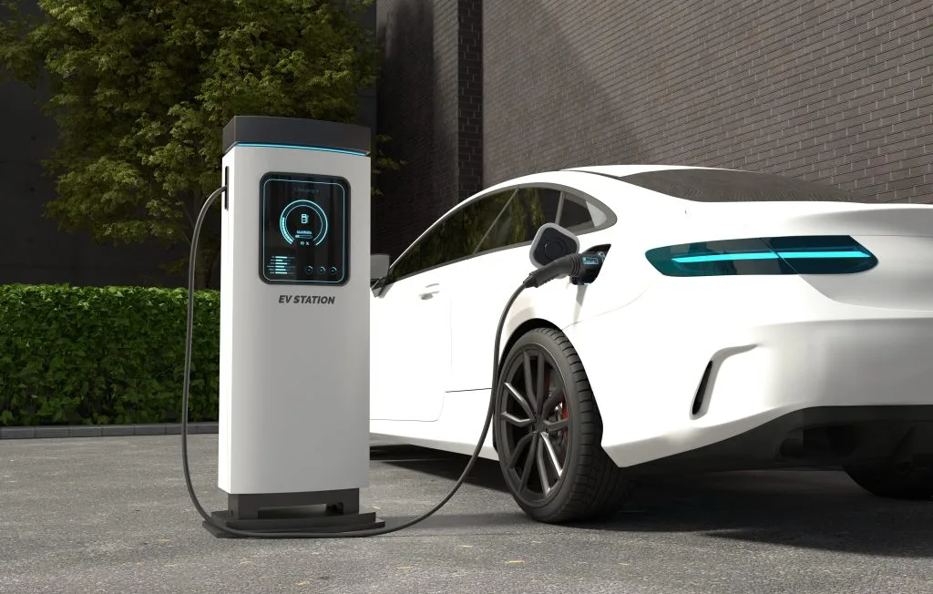 A white electric vehicle is charging at a modern charging station