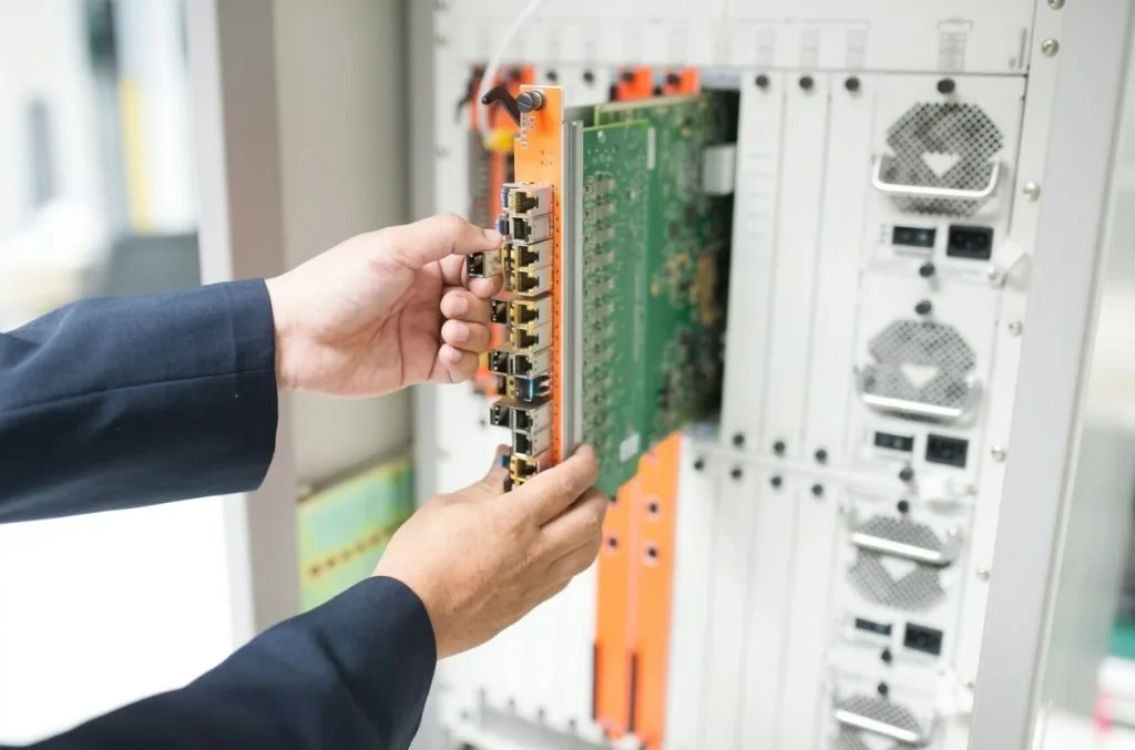 Electrician Airdrie installing a circuit board in a complex electronic device